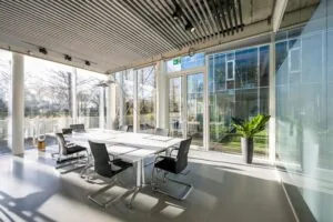 Lichte en moderne vergaderruimte aan de Fred. Roeskestraat met glazen wanden en uitzicht op een binnentuin.